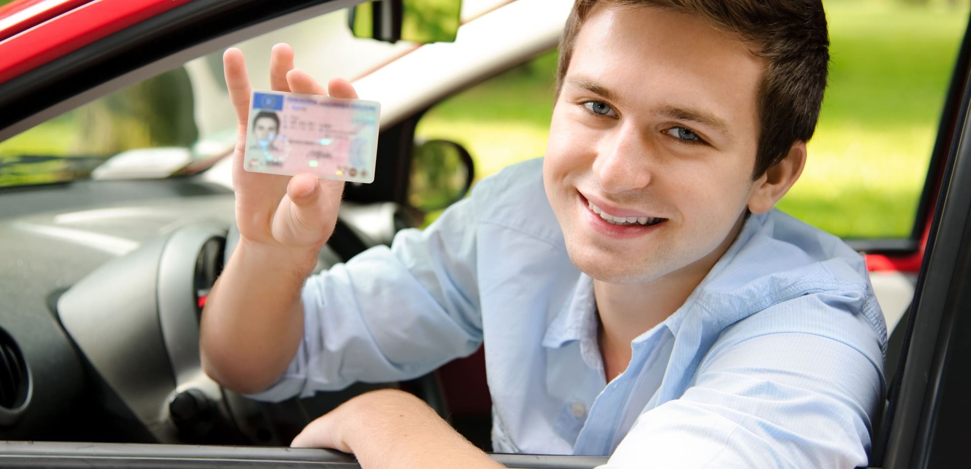 Fahrschüler zeigt glücklich seinen Führerschein